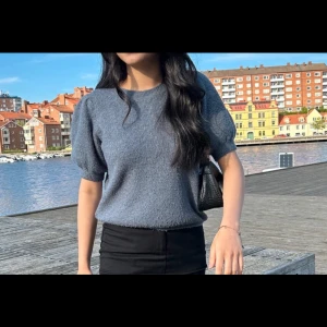 Blå stickad tröja - Säljer en stilren blå stickad tröja med korta ärmar. Perfekt för en avslappnad look. Tröjan har en mjuk och bekväm passform.