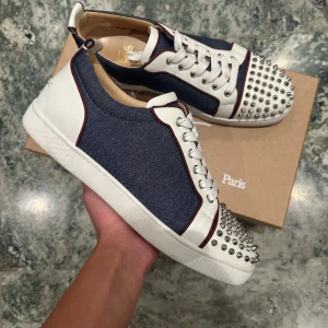 Christian Louboutin sneakers - Ett par skor coola loubs i storlek 43 med denim matrial! Allt ingår såsom Dustbags låda och extra spikar! Storlek 43