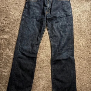 Levis 505 Limited Edition Jeans - Snygga Levis 505 Limited Edition jeans i mörkblå denim. Klassisk design med raka ben och knappgylf. Perfekta för en stilren look.