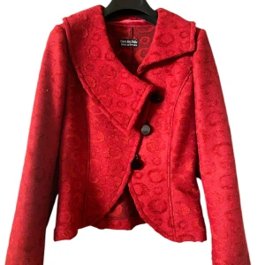 Röd kavaj från Gare De Robe - Snygg röd kavaj från Gare De Robe med unikt cirkelmönster. Tillverkad i Sverige, den har stora svarta knappar och en elegant krage. Perfekt för att ge en färgklick till din outfit.