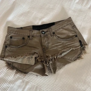  Shorts från One Teaspoon - Korta kakhigröna Jeansshorts frän One Teaspoon. Storlek 24, low waist. Använda fätalet ganger, inga defekter.