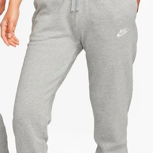 Grå mjukisbyxor från Nike - Snygga och bekväma grå mjukisbyxor från Nike med elastisk midja och dragsko. Perfekta för en avslappnad stil eller träning. Diskret Nike-logga på benet.