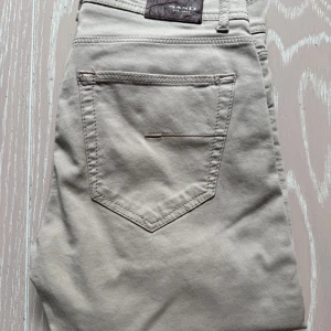 SandModern fit | Suede Touch Burton Byxor - Dessa Suede Touch Burton byxor från SAND COPENHAGEN ger en lyxig och stilfull look. Den supermjuka mocka ytan ger en unik touch och passformen anpassar sig till kroppsformen.