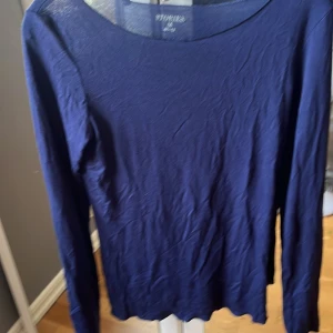 Mörkblå långärmad topp från Stories💕 - Säljer en stilren mörkblå långärmad topp från Stories.💕 Perfekt för en enkel och elegant look. Toppen har en rund halsringning och är tillverkad i ett mjukt material, jätte skön att ha på sig💕köpt på Ullared, nästan använd bara 2 gånger  💕