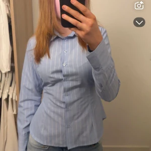 Skjorta - Säljer en jättefin skjorta från design by si😊helt oanvänd ! Knyt snören där bak och silvriga ränder🙂