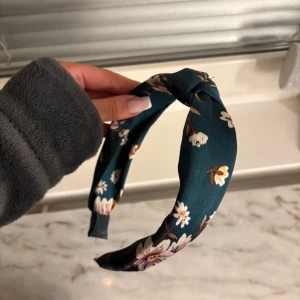 Blommigt diadem i satin - Snyggt diadem i satin med blommigt mönster. Perfekt för att ge en extra touch till din outfit. 