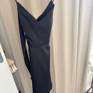Svart satin klänning  - Superfin, crossover i ryggen, använd en gång