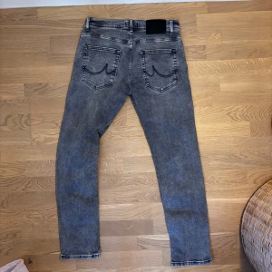 Grå jeans med slim passform - Snygga grå jeans med en slim passform. De har en klassisk femficksdesign. Perfekta för en stilren look.