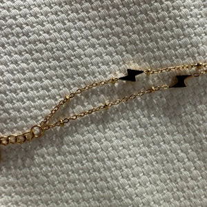 Helt nytt! Armband i rostfri stål - Helt nytt, aldrig använt. Armband med små blixtar på, guldfärgat, rostfri stål. Går att ställa i olika längder.