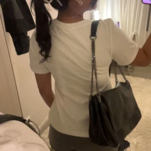 Vit t-shirt - Säljer en utsvängd vit t-shirt med rund hals och korta ärmar. Perfekt basplagg för alla tillfällen. T-shirten har en normal passform men går in runt midjan som gör den utsvängd längre ner, som jag tycker är jätte sött. 