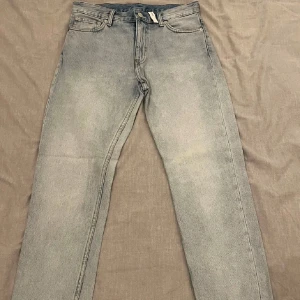 Ljusblåa jeans från Weekday - Säljer ett par ljusblå jeans från Weekday i modell ”Sunday” i bra skick. De har en klassisk straight fit och är tillverkade i slitstarkt denim. Perfekta för både vardag och fest! Storlek W30 L30.