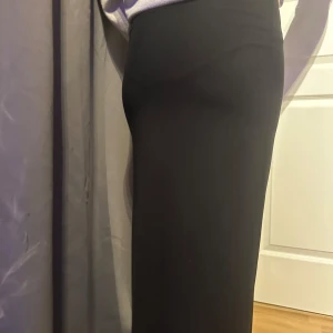 Svart långkjol - Elegant svart långkjol med en tight passform. Perfekt för en stilren look. Kjolen är enkel och klassisk, vilket gör den lätt att matcha med olika toppar.