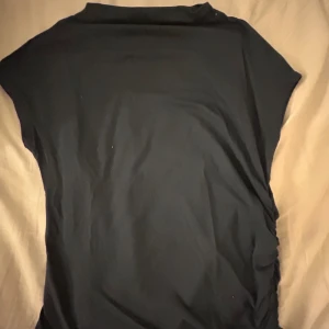 Mörkblå topp - Säljer en stilren mörkblå topp från lager 157 i storlek S. Toppen har en enkel design med korta ärmar och en rund hals. Perfekt för en minimalistisk look.