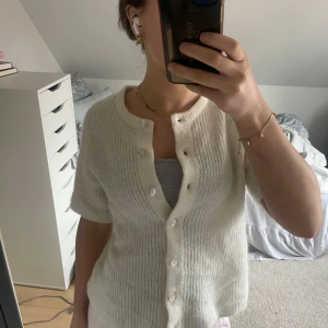 Vit ribbad kofta med knappar - Superfin kortärmad kofta/tröja från Gina tricot med knappar. Bara använd några få gånger, ser därmed så gott som ny ut!💕   Skriv för fler frågor eller bilder!