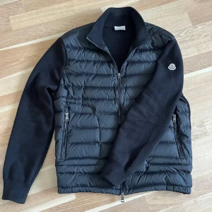 Moncler cardigan - Säljer en snygg svart cardigan från Moncler!Jackan har en stilren design och är perfekt nu till våren. Fraktsedel från Nk följer med på köpet, för fler bilder och frågor  kom privat🤝