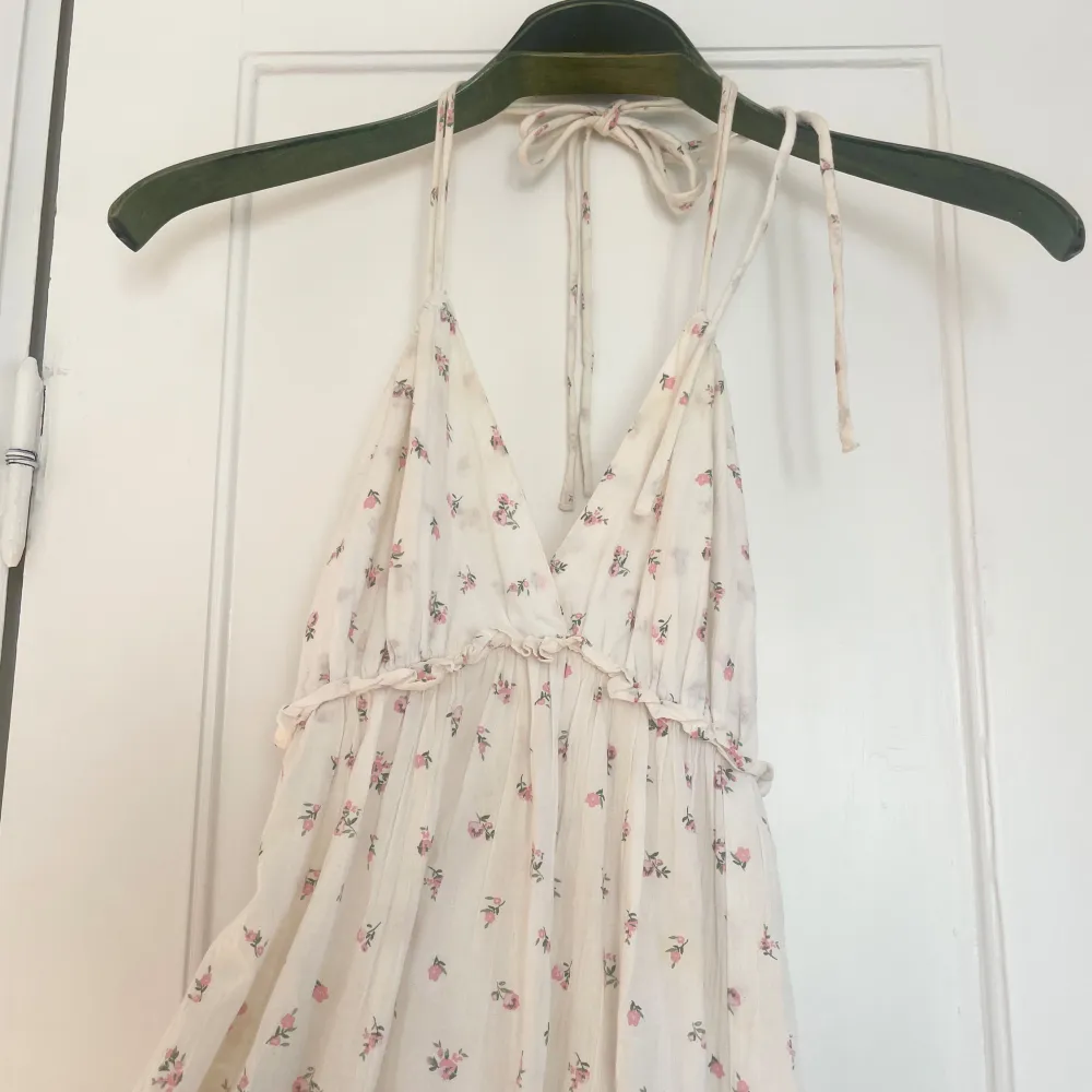 Idyllisk sommarklänning med blommor och volang! I strl xs & passar även s då man kan knyta vid halsen själv! . Mekot.