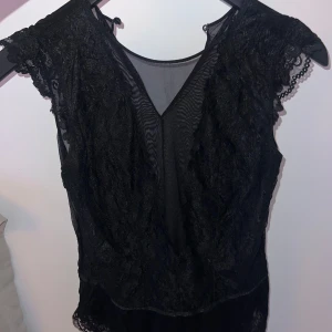 Svart spetsbody - svart spetsbody, spets fram till och genomskinlig i ryggen. 