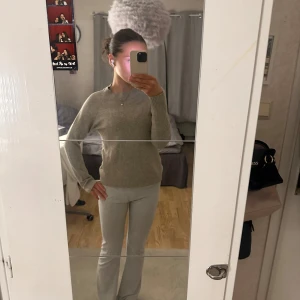 Beige stickad tröja - Säljer en stilren beige stickad tröja med långa ärmar. Perfekt för kyligare dagar och enkel att matcha med olika outfits. Tröjan har en klassisk design med ribbade muddar vid ärmslut och nederkant.