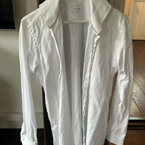 Vit skjorta från Eton - Säljer en stilren vit skjorta från Eton i storlek 41. Skjortan är knappt använd och inköpt för något år sen. Nypris: 2000kr pris nu: 150. Hör bara av er vid frågor!