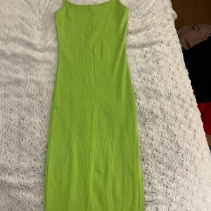 Grön ribbad klänning från newyorker - Snygg grön ribbad klänning från Amisu. Denna långklänning har en enkel och stilren design med smala axelband. Perfekt för en somrig look!