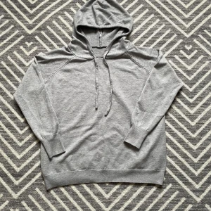 Grå hoodie - Säljer en stilren grå merinoull hoodie. Tröjan är helt ny och har ribbade muddar vid ärmslut och nederkant. Säljer för att den är för liten för mig. Perfekt för en avslappnad look. Otroligt trendig o väldigt snygg. Fråga vid minsta lilla fråga🤝