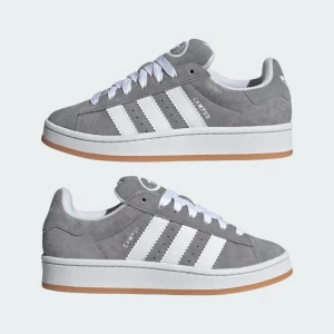 Grå Adidas Campus sneakers - Snygga grå Adidas Campus sneakers med vita detaljer och klassiska tre ränder på sidan. Skorna har en gummisula i ljusbrun färg och snörning framtill. Perfekta för en avslappnad stil.