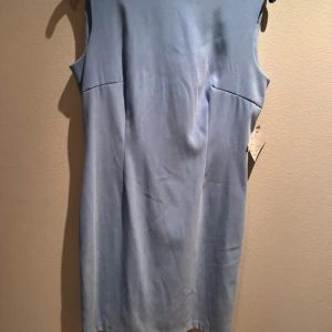 Ljusblå ärmlös klänning - Säljer en stilren ljusblå ärmlös klänning. Perfekt för en elegant look. Tillverkad i England och har en klassisk passform.