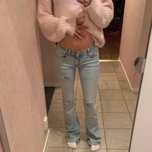 Ljusblå bootcut jeans med hål  - Snygga ljusblå bootcut jeans med slitna detaljer. De är lågmidjade och väldigt ljusa. Liknar free people jeansen. Man kan se lite av sömmen då jag sydde dom mer lågmidjade. Men det syns inte när man har dom på sig alls då den är emellan benen