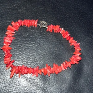 Rött armband med korallpärlor - Snyggt armband med röda korallpärlor i olika former. Armbandet har ett enkelt lås i metall som ger en säker passform. Perfekt för att lägga till en färgklick till din outfit.