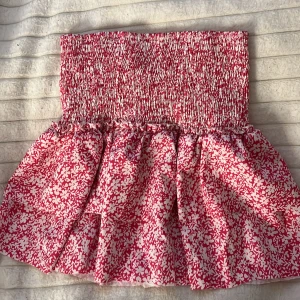 Rosa och vit blommig kjol - Rosa och vit blommig kort kjol. storlek M funkar för S och L 