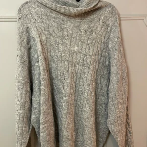 Grå stickad polotröja - Mysig grå stickad polotröja med kabelstickat mönster. Använd fåtal gånger