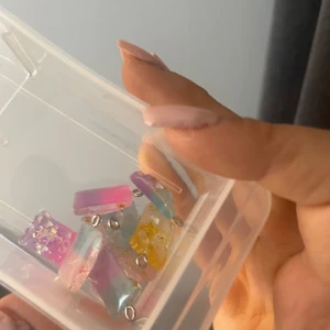 Färgglada sweet-påse berlocker  - Säljer ett set med färgglada berlocker. Varje smycke har en unik färgkombination med inslag av glitter och små stjärnor. Perfekta för att skapa egna smycken eller accessoarer. Alla berlocker som syns på bild ingår.