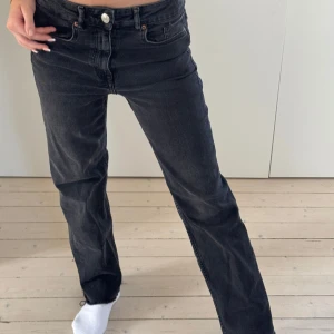 Svarta jeansbyxor - Snygga svarta jeansbyxor med låg midja.. Byxorna har en straight passform och stängs med dragkedja och knapp. Perfekta för en stilren look.