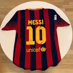 Äkta messi tröja  - Säljer en officiell FC Barcelona matchtröja från Nike med Messi 10 på ryggen. Tröjan är kortärmad, har klassiska blå och röda ränder, gul V-ringad krage och klubbmärke på bröstet. Materialet är lätt och andas, perfekt för fotboll eller att bära som supporter. Köpt i Barcelona !