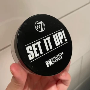 W7 Set It Up! Finishing Powder - Translucent finishing powder från W7 i en rund burk med svart lock. Perfekt för att fixera din bas och ge en matt finish. Lätt, vit puderformula som smälter in i huden utan att kännas tung. Kommer i en praktisk burk med siktlock för enkel applicering.