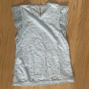 Ljusblå blus med spets  - Supersöt ljusblå blus som är perfekt till sommaren! Den är aldrig använd och är i super skick!