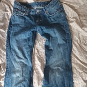 Blåa bootcut jeans - . Jeansen har fem fickor, knappgylf och snygga kontrastsömmar. Perfekta för dig som gillar tidlös stil och vill ha ett par jeans som funkar till allt.