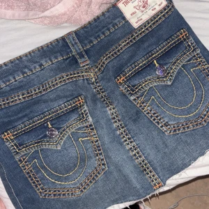 True Religion jeanskjol med stora fickor - Säljer en snygg jeanskjol från True Religion med ikoniska stora bakfickor och kontrastsömmar. Kjolen är helt nästan helt ny, har aldrig använt. (Har endast testats några gånger) säljer pga jag aldrig fått användning till den.