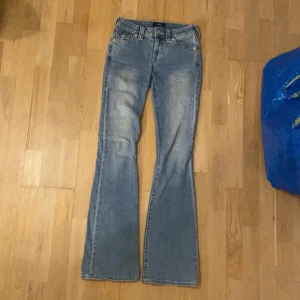 True Religion bootcut jeans blå - Hej! Jag säljer nu mina blåa true religion jeans då jag har köpt ett par nya i en annan modell. Jag har haft dessa jeans i ungefär ett år och det har aldrig varit några problem. Det är lite lite slitet längs ner på jeansen. Det är storlek 24 så jag skulle säga att dem passar en person med storlek xs/s. Hör gärna av er ifall ni är intresserade! 💕