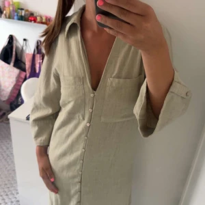 Grön linneskjortklänning med knappar - Snygg klänning från Zara med knappar framtill. Använd en gång innan och är inprincip som helt ny. Kontakta mig via intresse eller funderingar!❤️