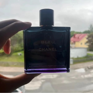 Bleu de Chanel Eau de Parfum - Bleu de Chanel Eau de Parfum för herr, ikonisk doft i elegant mörkblå glasflaska med silverdetaljer och svart lock med Chanel-logga. Kommer med original svart kartong. Flaskan är fyrkantig och stilren, perfekt för dig som gillar exklusiva parfymer. med runt 47ml kvar