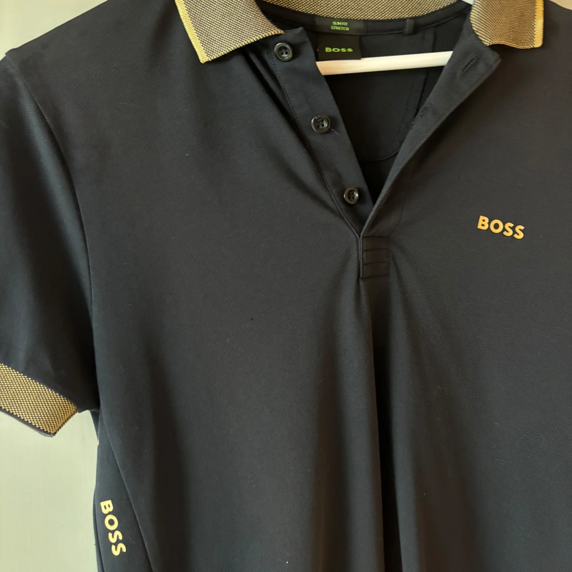 Svart pikétröja från BOSS med gulddetaljer - 1