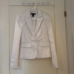 Vit lite glansig kavaj - Vit kavaj i storlek 34. Använd någon enstaka gång.