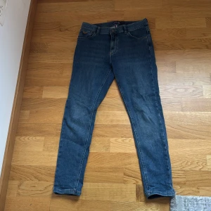 Blå skinny jeans från U.S. Polo Assn. - Snygga blå skinny jeans från U.S. Polo Assn. med klassisk femficksdesign och bruna sömmar. Jeansen har normalhög midja, bälteshällor och en patch med logga bak. Perfekta för dig som gillar en smal passform och tidlös denimstil.
