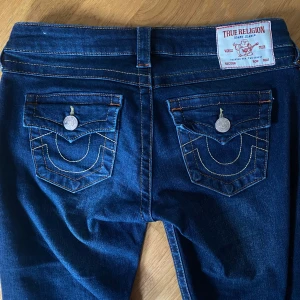 True Religion Jeans - Mörkblå true religon joey low rise flare jeans. Det finns några slitningar på slutet men det är inget som syns. Måtten kan ni skriva om privat🩷