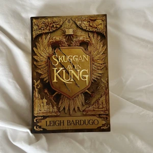 Skuggan av en kung - Första delen i en ny serie i Grishaverse! Följ kung Nikolai och hans allierade i en värld fylld av magi, hemligheter och faror. Perfekt för dig som älskar spänning, fantasy och episka äventyr. Boken ligger till grund för Netflix-serien Shadow and Bone.