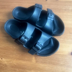 32Biox Sandaler Svarta Storlek 32 - Ett par svarta sandaler från 32Biox. Perfekt för varma dagar eller som bekväma inneskor. Sandalerna har justerbara remmar för bästa passform.