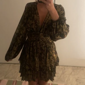 Zara klänning - Supersnygg kort klänning i svart och guld med plisserad kjol och djup v-ringning. Jätte nice fest klänning!!💕