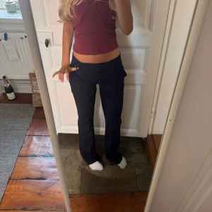 Mörkblå kostymbyxor med raka ben - Snygga mörkblå kostymbyxor med normal passform och raka ben. Byxorna har klassisk midja, hällor för bälte och sidfickor. De är egentligen högmidjade men jag har sytt ner dem så de är lågmidjade, därför är de lite vikda vid skrevet💕 Innerbenslängd: 82cm. Midja rakt över: 37cm.