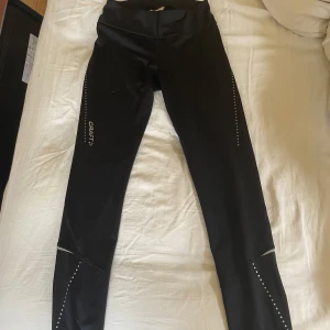 Tränings tights - Ett par tränings tights från craft i storlek s. Byxorna har en ficka på baksidan och går att öppna längst ner på benet